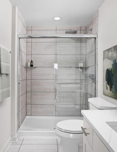 Bathroom Featuring Walk-In Shower With Glass Sliding Door
